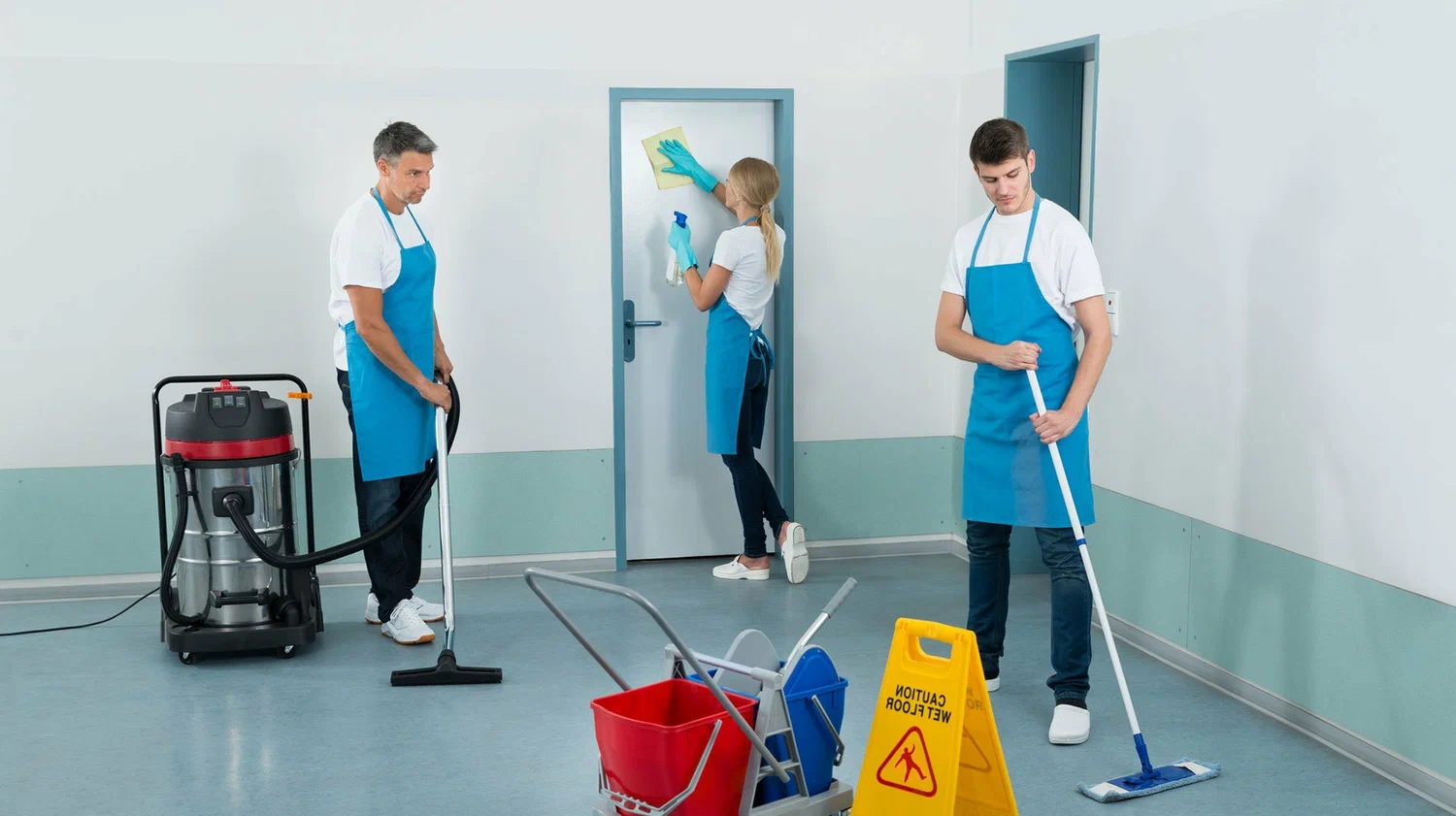 Three workers are cleaning the floor and the door together